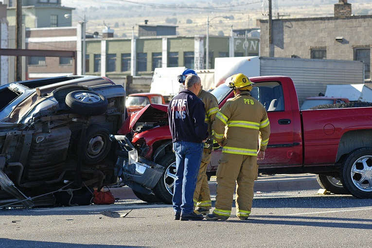 "firemen in front of vehicle crash with red pickup truck"